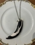 Colar na cor prata,45cm mais alongador, com dente de pedra preto e branco e acabamento na cor prata.