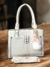 Lady Bags Premium acompanha Pompom e Alça removível na internet