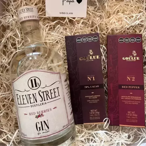 Botella de gin Eleven Street Red Berries junto a dos tabletas de chocolate de La Goulue, una de 70% cacao y otra con pimienta roja, todo en una caja de regalo.