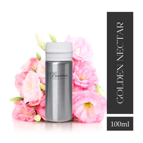 Frasco de fragancia Golden Nectar Floral de 100 ml rodeado de flores rosas.