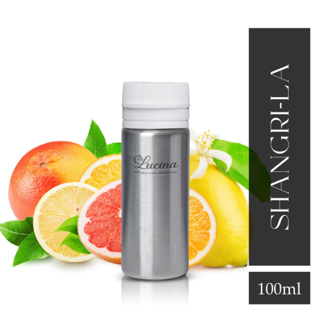 Frasco de fragancia Shangri-La de 100ml con notas de té y cítricos, rodeado de frutas cítricas como limón, pomelo y naranja.