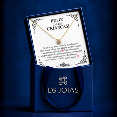 Colar folheado a ouro com pingente redondo cravejado de pedras, em embalagem azul com mensagem de Dia das Crianças da DS Joias.