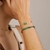 pulseira dourada com pingente de coração verde