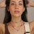 colar choker dourada com pingente de coração verde na internet