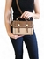 Bolsa transversal Roma pequena em tom marrom e bege, segurada por uma mulher. O acessório possui detalhes em costura e fechos dourados.