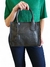 Bolsa feminina tiracolo média na cor preta, com detalhes em costura lateral, segurada por uma mulher vestindo uma blusa verde.