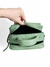 Bolsa feminina transversal baú média verde menta em couro legítimo, sendo aberta por uma mão.