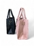 Imagem de duas bolsas femininas tiracolo médias, uma preta e outra rosa, exibindo detalhes de design.
