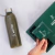 Botella transparente con bebida verde y caja verde de sobres Matter, mano sosteniendo un sobre