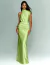 Mulher vestindo um vestido longo de festa verde lima com gola alta.