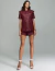 Modelo usando camisa oversize verde marsala Noir com shorts combinando e sandálias brancas.