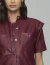 Camisa oversize feminina em tom marsala, com botões frontais e bolsos, modelo de manga curta.