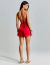 Mulher vestindo o conjunto Éclat Ligne vermelho, com top de alças finas cruzadas nas costas e amarração, acompanhado de shorts curtos, vista de costas.