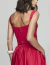 Costas de uma mulher vestindo o Conjunto Bordado Vermelho Raw, mostrando detalhes do tecido vermelho e zíper traseiro.