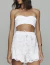 Mulher vestindo conjunto de renda off white Wildflower, com top tomara que caia e shorts rendados.