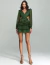 Mulher vestindo um vestido curto elegante verde com mangas longas e babados, ideal para festas e eventos especiais.