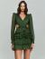 Mulher vestindo um vestido curto verde com mangas longas e detalhes plissados.