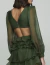 Detalhe das costas de um vestido curto verde com mangas longas em tecido leve e babados, ideal para festas e eventos sofisticados.