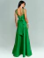 Vestido de festa longo verde bandeira com laço nas costas, usado por mulher de cabelos longos.