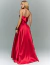 Mulher vestindo vestido de festa longo vermelho Liberec, com saia fluida e tomara que caia, vista de costas.