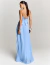 Mulher vestindo o Vestido Longo Dancing Wind Azul, com alças finas cruzadas nas costas e saia plissada, posando de costas em estúdio.