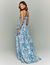 Mulher vestindo um vestido longo com estampa floral azul, estilo Dream Garden.