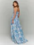 Mulher vestindo um vestido longo com estampa floral azul, estilo Dream Garden.
