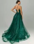 Mulher usando vestido de festa longo bordado verde floresta Lunara, com alças finas cruzadas nas costas e saia volumosa com brilho.