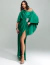 Modelo usando vestido de festa longo verde bandeira com um ombro só e detalhe brilhante na cintura.
