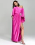 Vestido de festa longo um ombro só pink Manisa com fenda e detalhe de broche prateado, usado por modelo.