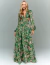Vestido de festa longo verde com estampa floral, manga longa e recortes laterais, modelo Rieti.
