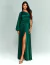Mulher vestindo vestido de festa longo verde floresta com uma manga bufante e fenda na perna, modelo Santorini.