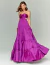 Mulher usando um vestido de festa longo fúcsia com amarração, design elegante e sofisticado.