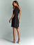 Vestido de festa curto preto com capa, posando de lado ideal para convidada de casamento, convidada de formatura, festa