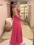 Mulher usando vestido de festa longo de cetim pink Quênia em um provador elegante.