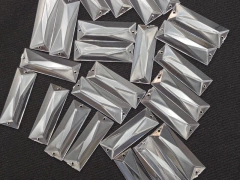 Meias pastilhas acrílicas retangulares facetadas de 17x50 mm, em diversas posições sobre um fundo escuro.