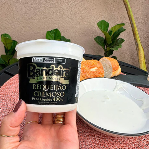 Potinho de requeijão cremoso da Linha Nobre Bandeira, com pão ao fundo.