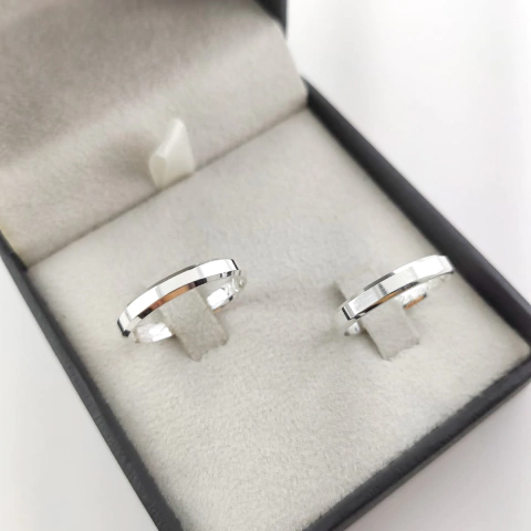 Dupla de alianças de prata chanfradas de 3mm, apresentadas em uma caixa elegante.