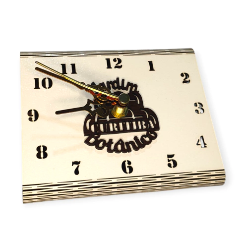 Relógio ecológico de mesa com design do Jardim Botânico de Curitiba, mostrando os números e ponteiros em destaque.