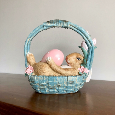 COELHA EM RESINA DEITADA NA CESTA SEGURANDO OVO 23CM