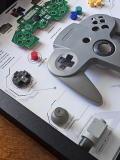 Quadro controle do videogame Nintendo 64 com as peças desmontadas e emoldurado