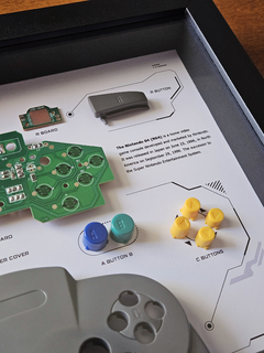 Quadro controle do videogame Nintendo 64 com as peças desmontadas e emoldurado