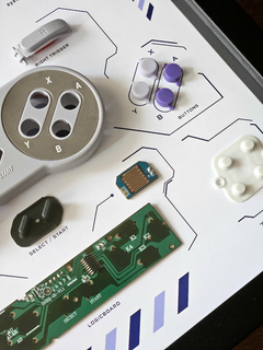 Quadro controle do videogame Super Nintendo (SNES) com as peças desmontadas e emoldurado