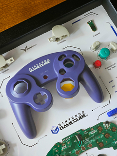 Quadro controle do videogame Nintendo GameCube com as peças desmontadas e emoldurado