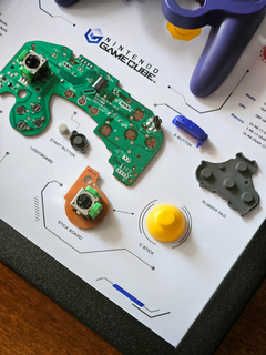 Quadro controle do videogame Nintendo GameCube com as peças desmontadas e emoldurado