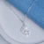 Colar de prata 925 com pingente de lua cravejada de zircônias e estrela lisa, sobre fundo claro.