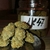 Cogollos de cannabis AK 47 sobre una balanza, con un frasco de almacenamiento al fondo.