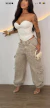 Mulher vestindo calça cargo jogger jeans bege com cordão na barra, blusa tomara que caia branca e sandálias de salto alto transparentes