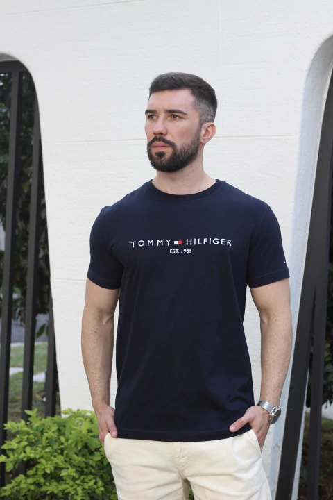 Camiseta Tommy Hilfiger marinho com estampa frontal e detalhe de ano de fundação, modelo masculino.