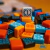 Peças coloridas do jogo de tabuleiro Azul, incluindo cubos azuis, laranja, amarelos e pretos com padrões decorativos, e um dado branco com o número 1